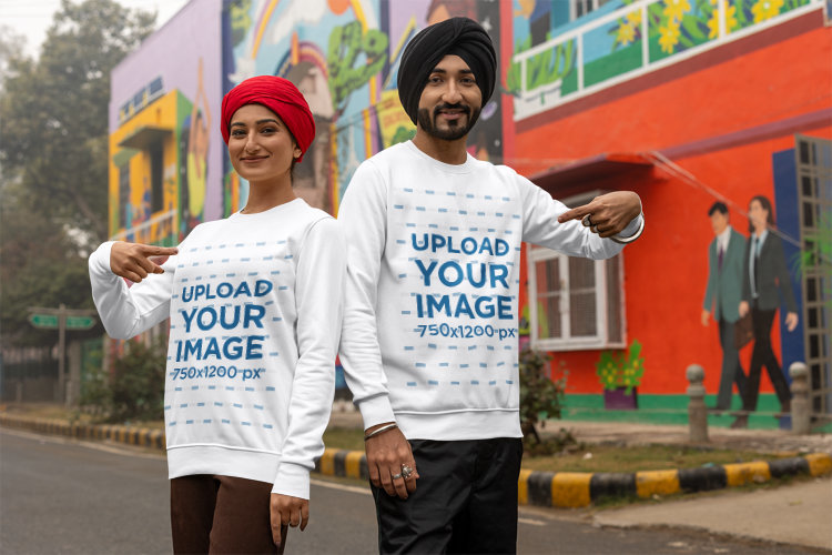 Mockup of a Man and a Woman with Turbans Pointing at Their Crewneck Sweatshirts