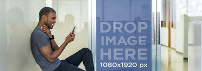 Mockup of a Young Man Sitting Outside and Using His Smartphone