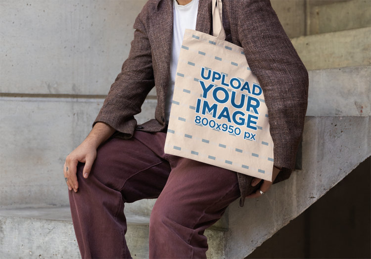 Tote Bag Mockup Featuring a Cropped-Face Person Sitting on a Staircase