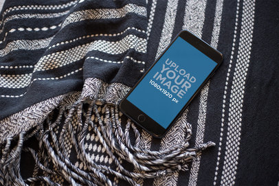 Mockup of a Space Gray iPhone Lying on a Wool Blanket a21513
