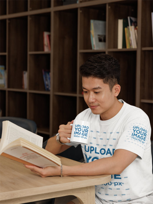 Gildan T-Shirt Mockup of a Man Reading While Holding a Coffee Mug
