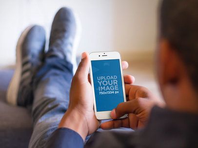 Mockup of Man Relaxing With His Feet Up While Using a White iPhone 6