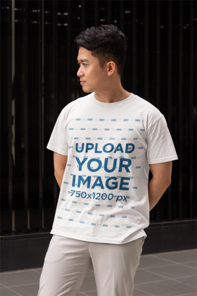 Gildan T-Shirt Mockup Featuring a Serious Man Standing by the Sidewalk