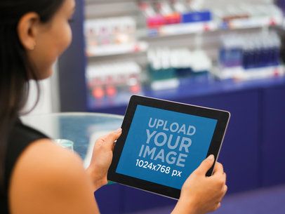 Mockup of a Woman Holding a Black iPad in Beauty Shop