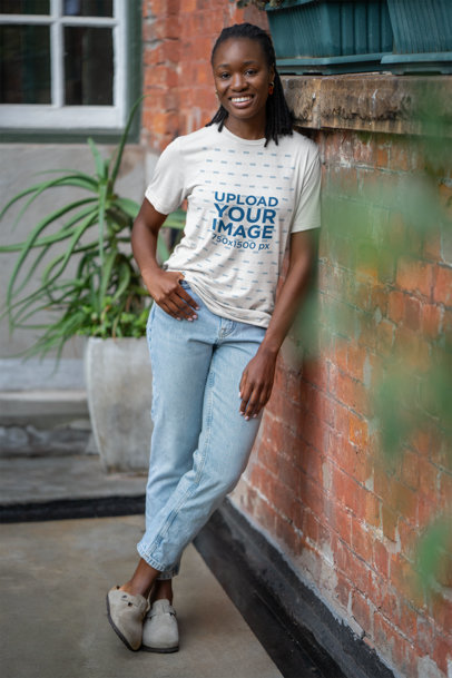 Bella Canvas Mockup of Cheerful Woman Wearing a Round-Neck T-Shirt and Posing on Brick Wall