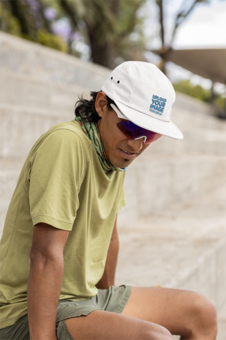 Yupoong Panel Hat Mockup Featuring a Man Sitting on Concrete Bleachers With Running Clothes