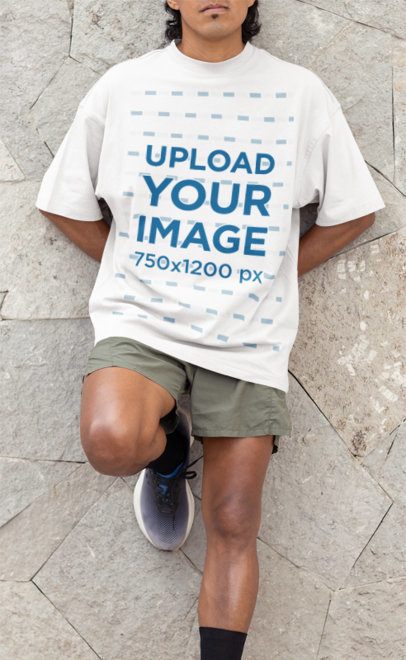 Oversized T-Shirt Mockup of a Runner Leaning Against a Wall
