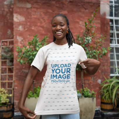 Mockup of a Happy Woman Pointing at Her Crewneck Bella Canvas T-Shirt