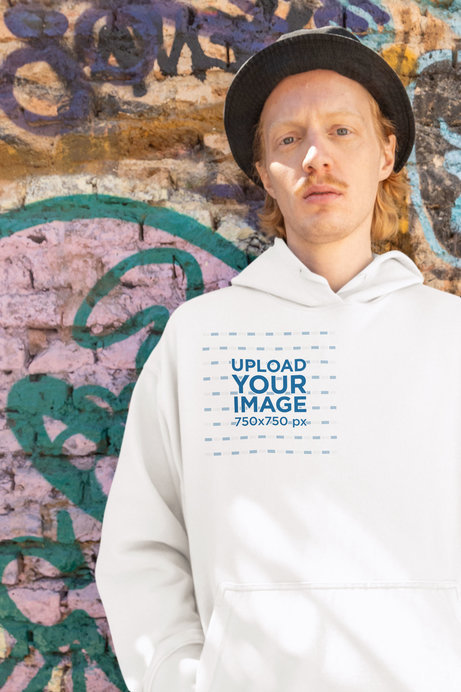 Hip Hop-Inspired Mockup Featuring a Man Wearing a Hoodie Against a Graffiti Wall