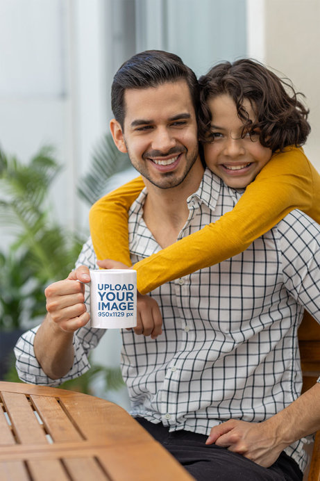 Coffee Mug Mockup Featuring a Smiling Man Being Hugged By His Son