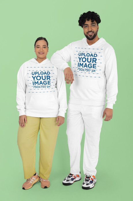 Mockup of a Man and a Woman Wearing Matching Plus Sized Hoodies in a Studio