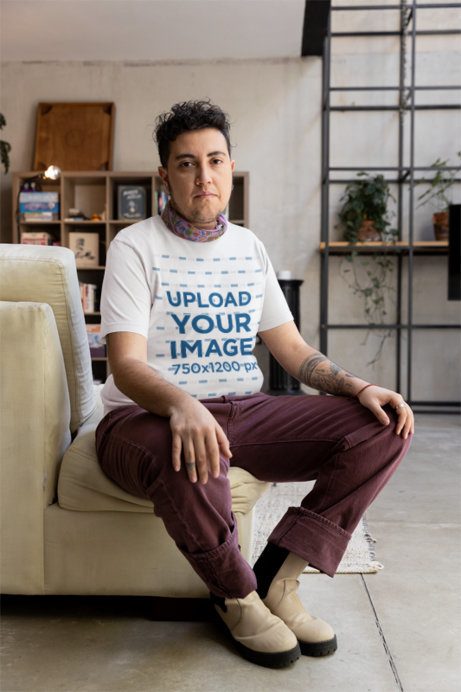 Mockup of a Person Sitting at Home Wearing a Bella Canvas T-Shirt
