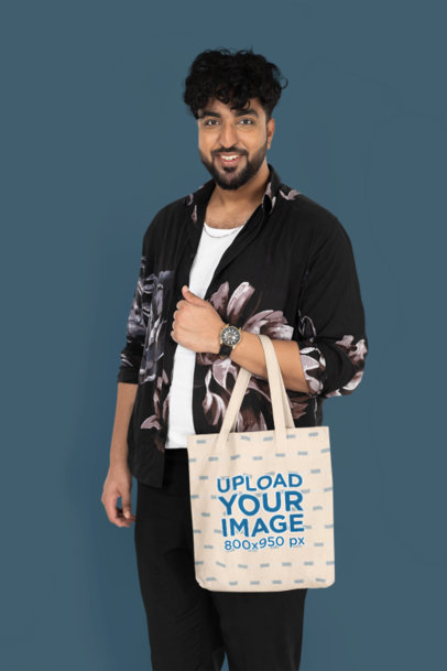 Mockup of a Happy Man Carrying a Sublimated Tote Bag in a Studio