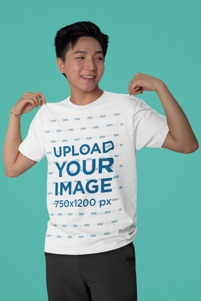 Mockup of a Cheerful Man Showing Off His Bella Canvas Round-Neck T-Shirt in a Studio m40242