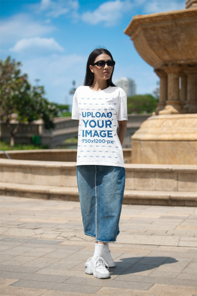Mockup of a Woman Wearing an Oversized Bella Canvas T-Shirt on the Street