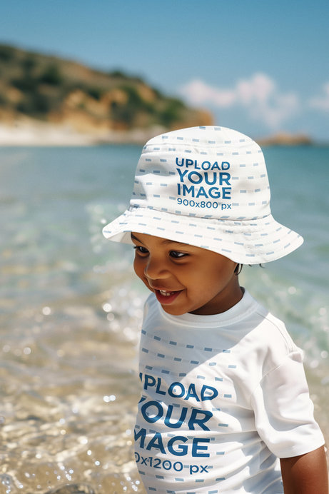 Bucket Hat and T-Shirt Mockup of an AI-Generated Baby Boy Playing by the Sea