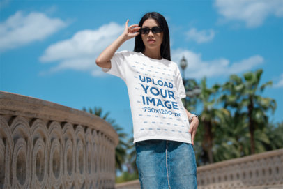 Bella Canvas Mockup Featuring a Woman Posing With an Oversized Tee by the Street