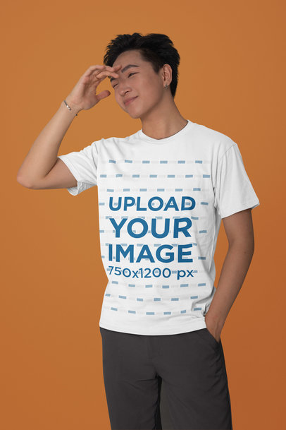 Mockup of a Man Standing in a Studio Wearing a Bella Canvas T-Shirt 