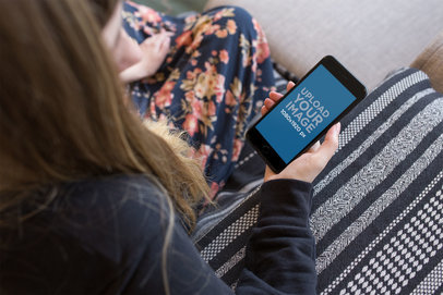 Overshoulder Space Gray iPhone Mockup of a Woman on a Sofa