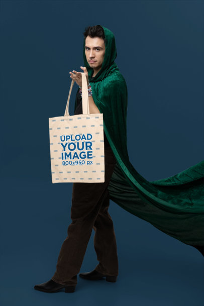 Tote Bag Mockup Featuring a Serious Man Wearing a Witchy Cape Inspired by a Swift Fandom Outfit
