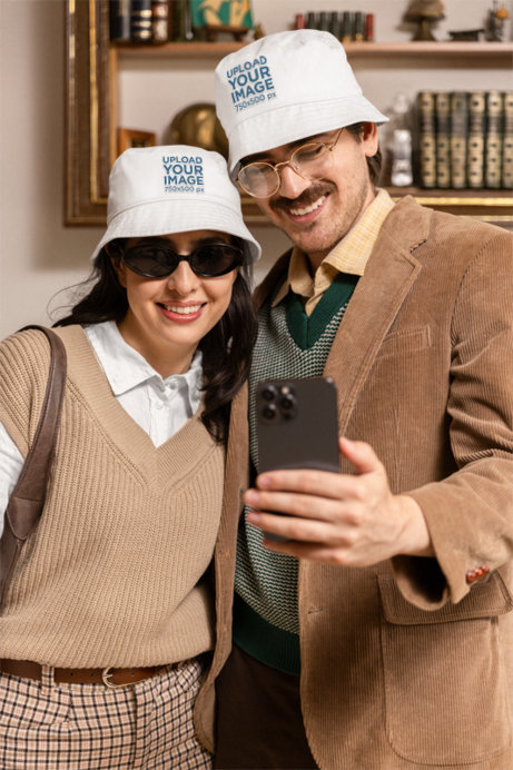 Bucket Hat Mockup Featuring a Smiling Man and a Woman With Grandpacore Style Taking a Selfie