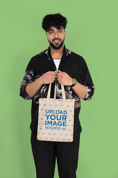 Mockup of a Smiling Bearded Man Carrying a Sublimated Tote Bag in a Studio