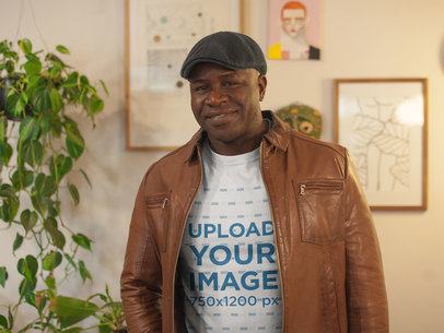 T-Shirt Mockup Featuring a Smiling Senior Man with a Beret