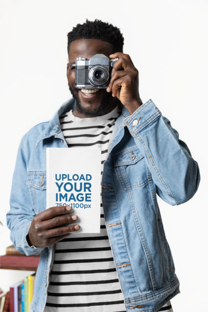 Mockup of a Cheerful Man With a Vintage Camera Holding a Hardcover Book