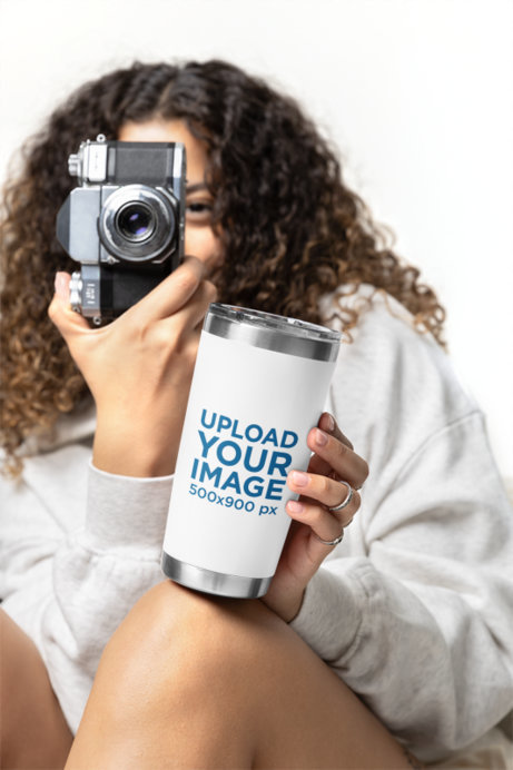 Travel Mug Mockup Featuring a Curly-Haired Taking a Picture With a Vintage Camera