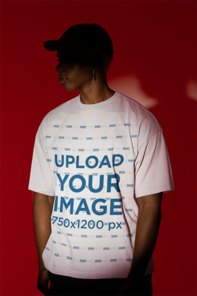 Oversized T-Shirt Mockup of a Man Standing in the Spotlight of a Studio m50048