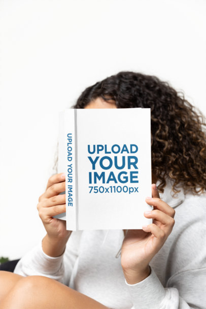 Mockup of a Woman Hiding Behind a Hardcover Book