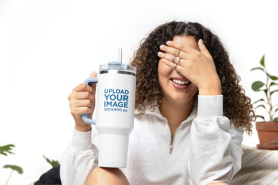 Mockup of a Joyful Woman Holding a Stanley Tumbler and Covering Her Eyes With Her Hand m40301