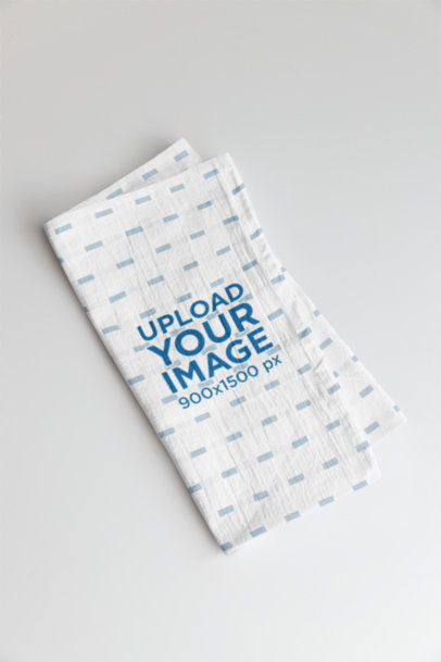 Mockup of a Sublimated Folded Cotton Tea Towel Lying on a Plain Surface m40743