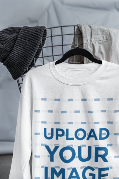 Mockup of a Gildan Sweatshirt Mockup Placed on a Hanger With a Streetwear Outfit