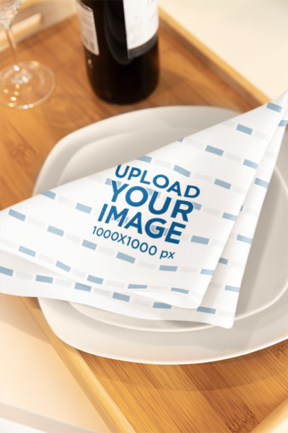 Mockup of a Sublimated Cloth Napkin Placed on Two Plates for a Table Setting m40755