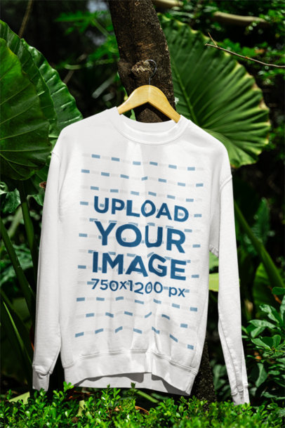 Mockup of a Gildan Crewneck Sweatshirt Hanging from a Tree Surrounded by Plants m39849