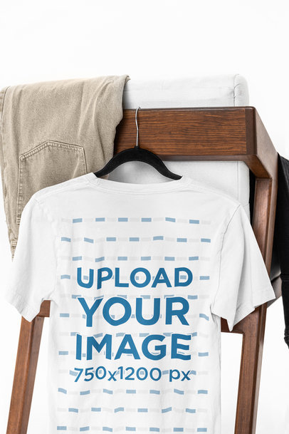Mockup of the Back View of a Bella Canvas T-Shirt Hanging From a Chair m39749