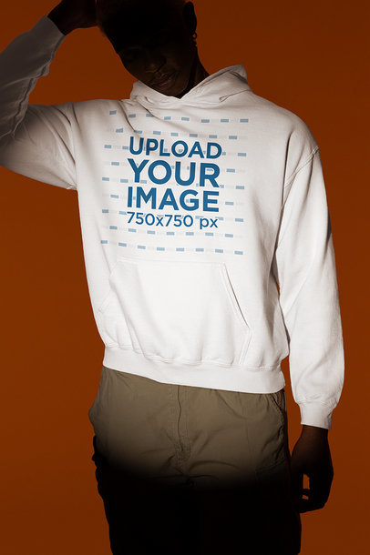 Gildan Pullover Hoodie Mockup of a Man Posing Under a Spotlight in a Studio
