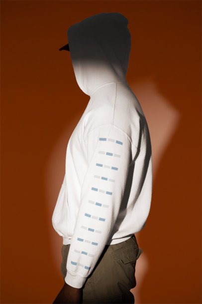 Gildan Hoodie Mockup Featuring a Man With a Customizable Sleeve Standing Under a Spotlight