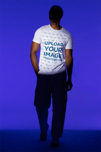 Bella Canvas T-Shirt Mockup Featuring a Man Standing in a Studio's Spotlight 