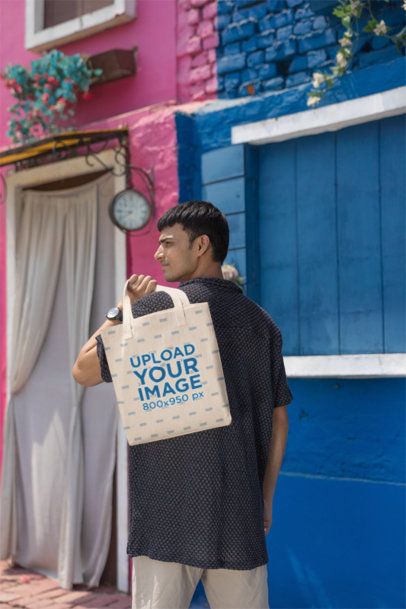 Mockup of a Gen Z Man Carrying a Sublimated Tote Bag on the Street m41019