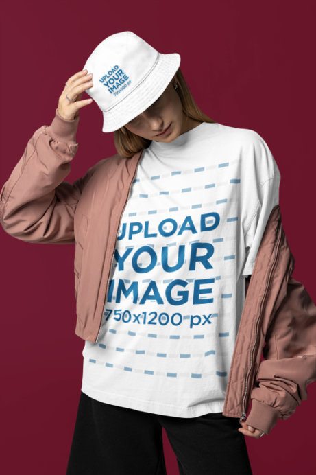 Oversized T-Shirt Mockup Featuring a Woman Wearing a Bucket Hat and a Jacket