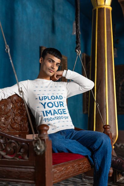 Bella Canvas Long-Sleeve Tee Mockup Featuring a Man Sitting in a Hanging Chair m40982