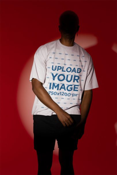 Mockup Featuring a Man Wearing an Oversized T-Shirt in the Middle of a Spotlight