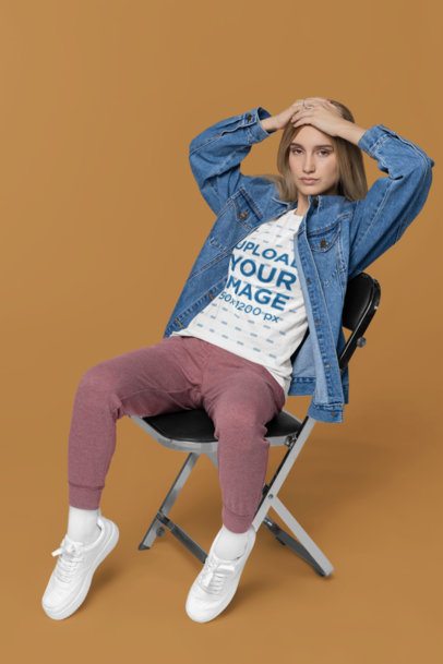 Bella Canvas T-Shirt Mockup of a Woman with a Denim Overshirt Sitting on a Chair