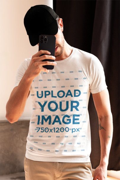 Bella Canvas T-Shirt Mockup of a Bearded Man With Tattoos Taking a Selfie