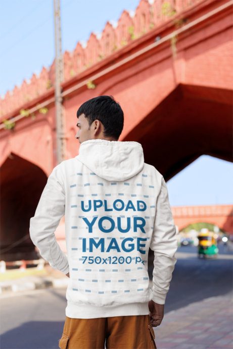 Back-View Gildan Hoodie Mockup Featuring a Gen-Z Man Standing on the Sidewalk