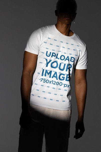Bella Canvas Tee Mockup of a Man Posing Under a Spotlight in a Studio