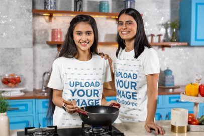 Scott International T-Shirt Mockup Featuring a Happy Teenage Girl With Her Mom Cooking in a Kitchen m41123