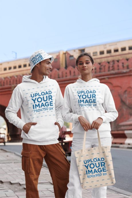 Gildan Hoodie Mockup of a Gen Z Man With a Bucket Hat Posing With a Woman Holding a Tote Bag